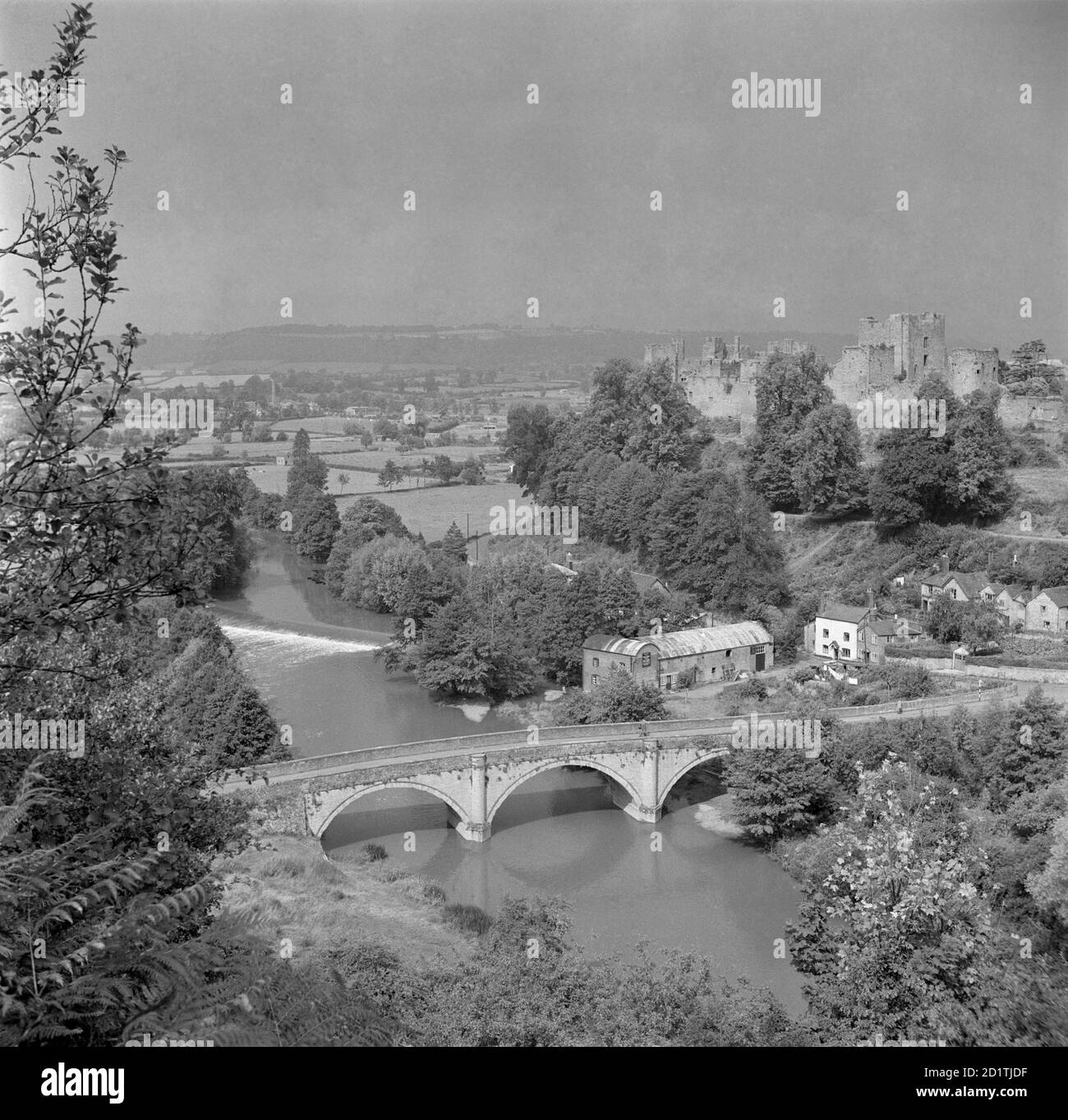 PONT DE DINHAM, Ludlow, Shropshire. Vue générale à partir d'une position surélevée montrant la rivière Teme au premier plan. Le pont de Dinham à Ludlow a été construit en 1823. La présence imposante du château de Ludlow peut être vue en arrière-plan. Photographié par Eric de Mare entre 1945 et 1980. Banque D'Images