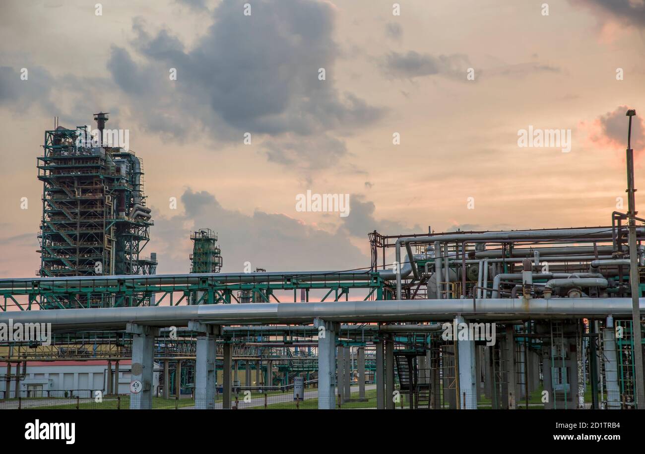 Tour de raffinerie dans une usine pétrochimique à ciel nuageux. Après le coucher du soleil. Banque D'Images