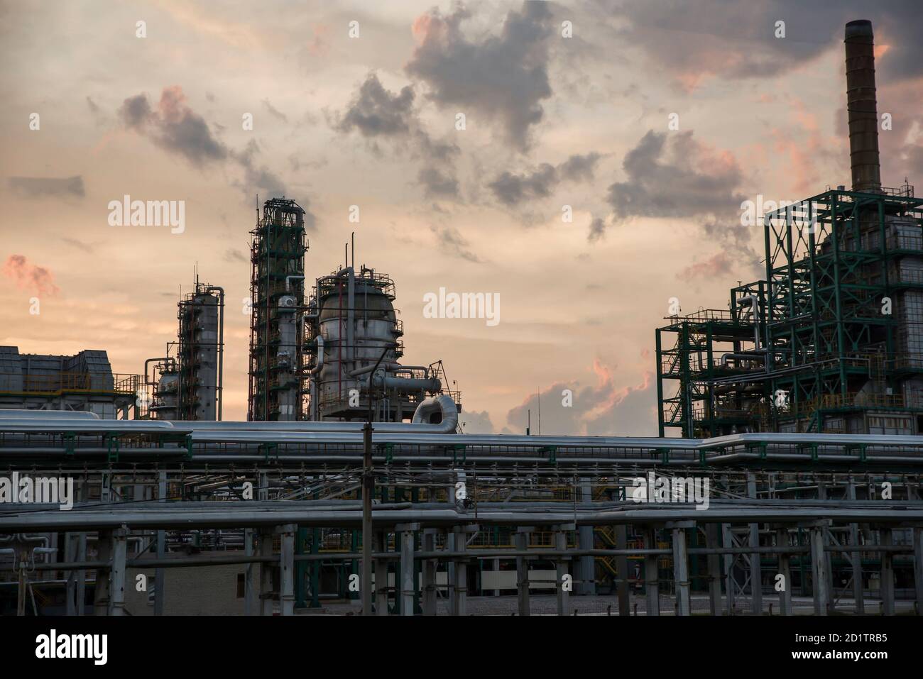 Tour de raffinerie dans une usine pétrochimique à ciel nuageux. Après le coucher du soleil. Banque D'Images