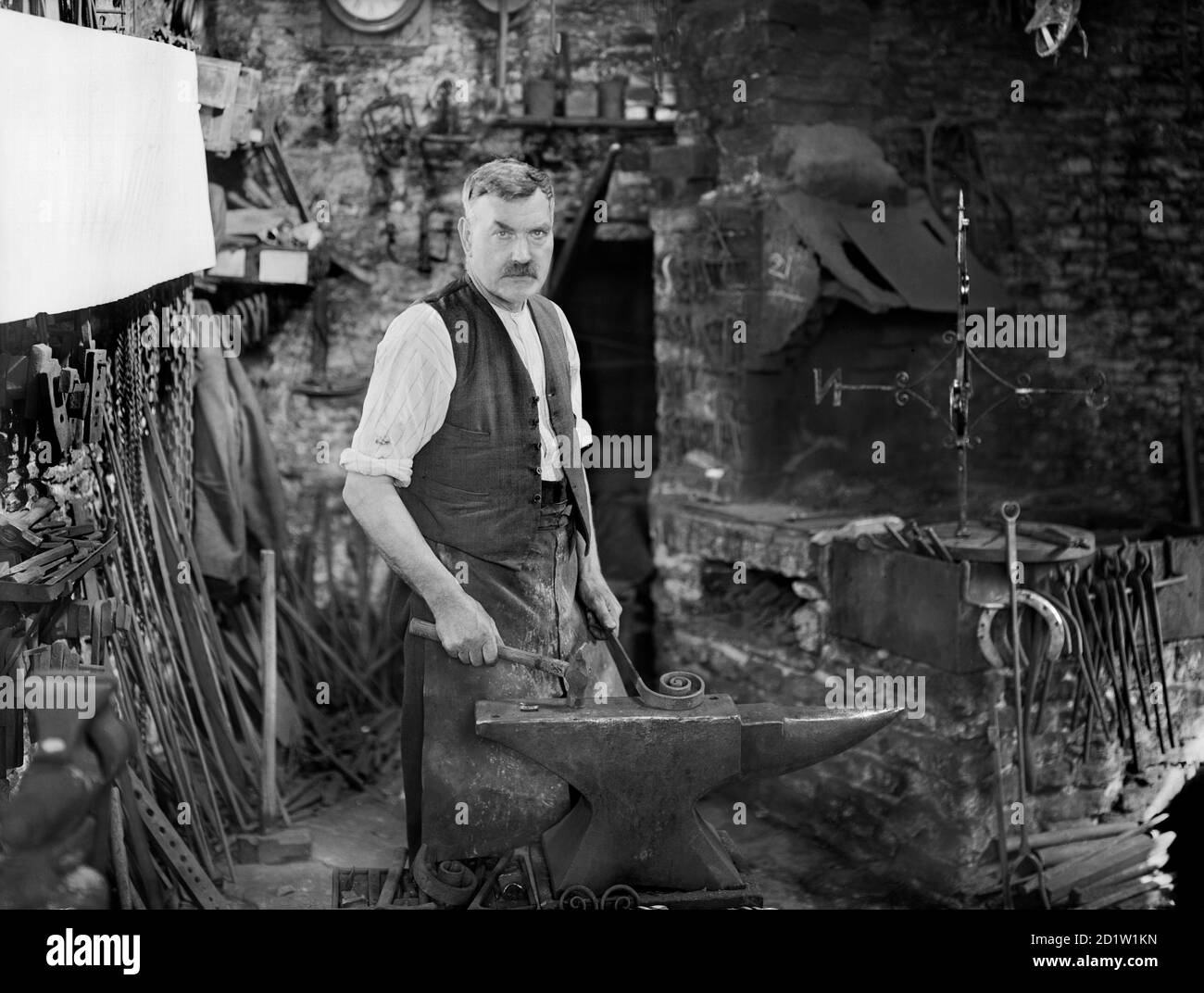 Vue intérieure de la Forge, montrant M. Jefferies au travail, Cotswolds, Gloucestershire, Royaume-Uni. Banque D'Images