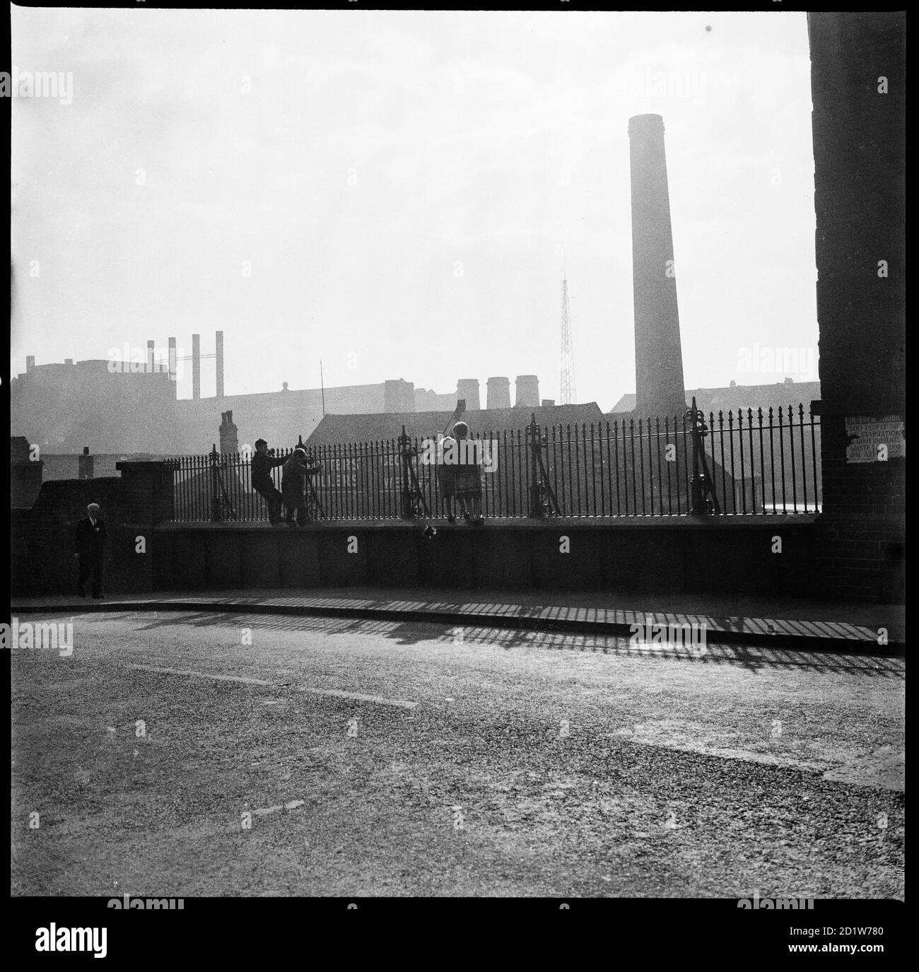 Un groupe d'enfants regardant vers George Goodwin et sons' Westwood Mills depuis le pont qui transporte la A50 (rue Lichfield) au-dessus du canal Caldon, Hanley, Stoke-on-Trent, Staffordshire, Royaume-Uni. Banque D'Images