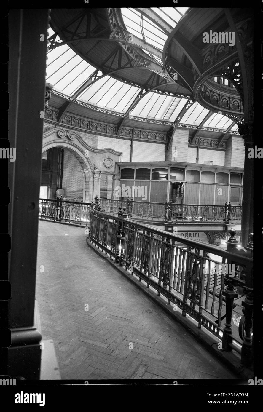 Vue intérieure des marchés de la ville, vue d'un balcon sur un côté court du hall, montrant une porte interne à une autre section du marché avec une cabine en bois avec des panneaux de verre et une vue partielle des étals sous. Banque D'Images