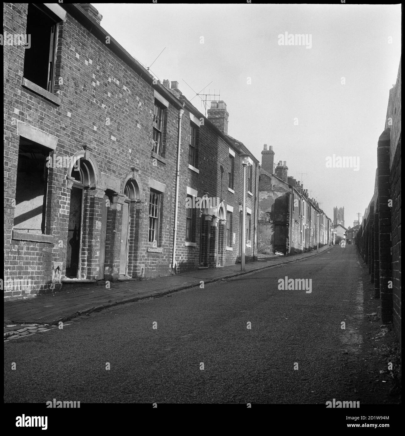 Vue vers l'est le long des maisons mitoyennes de Bedford Street avec le mur limite des travaux de Bedford à l'extrême gauche et la tour de l'église St Marc au loin. Banque D'Images