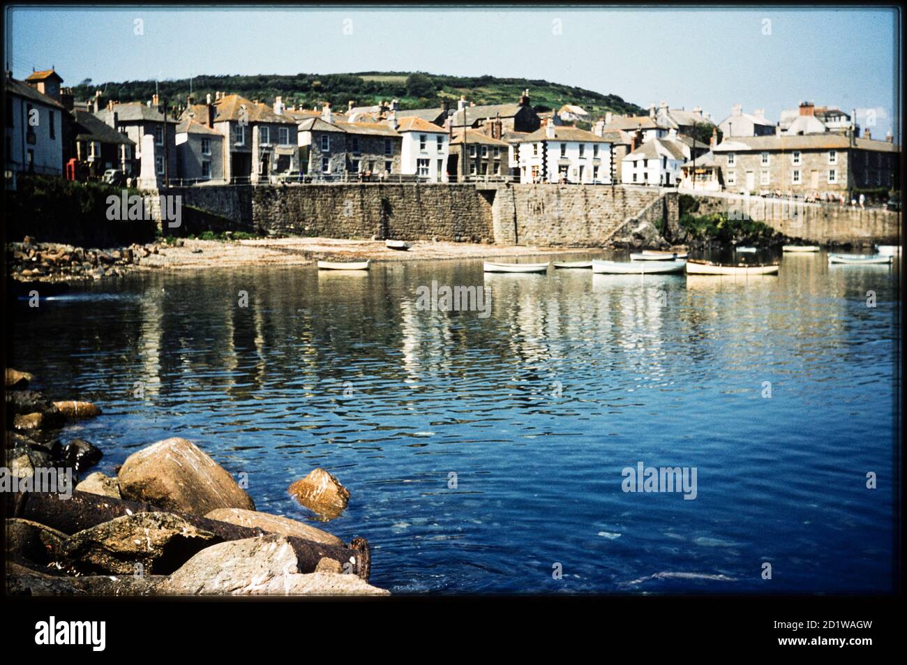 Port de Mousehole, Mousehole, Penzance, Cornouailles. En regardant vers le nord à travers le port de Mousehole depuis le bord des rochers entre le quai et la jetée sud, le port de Mousehole a été construit pour la première fois en 1392. Les jetées ont été construites aux XVIIe et XIXe siècles. Banque D'Images