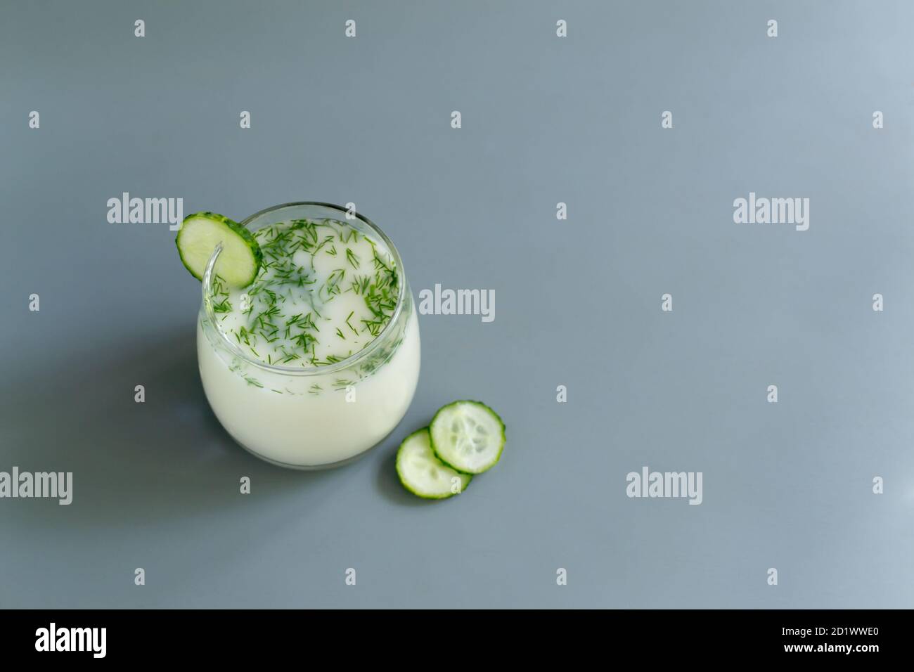 Ayran dans un verre avec aneth et concombres sur fond gris. Concept de produit fermenté. Copier l'espace. Mise au point sélective Banque D'Images