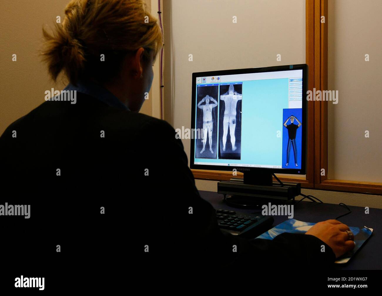 A security officer examines a computer screen showing a scan from a  RapiScan full-body scanner, being trialled by Manchester Airport, during a  photocall at the airport, in Manchester, northern England January 7,