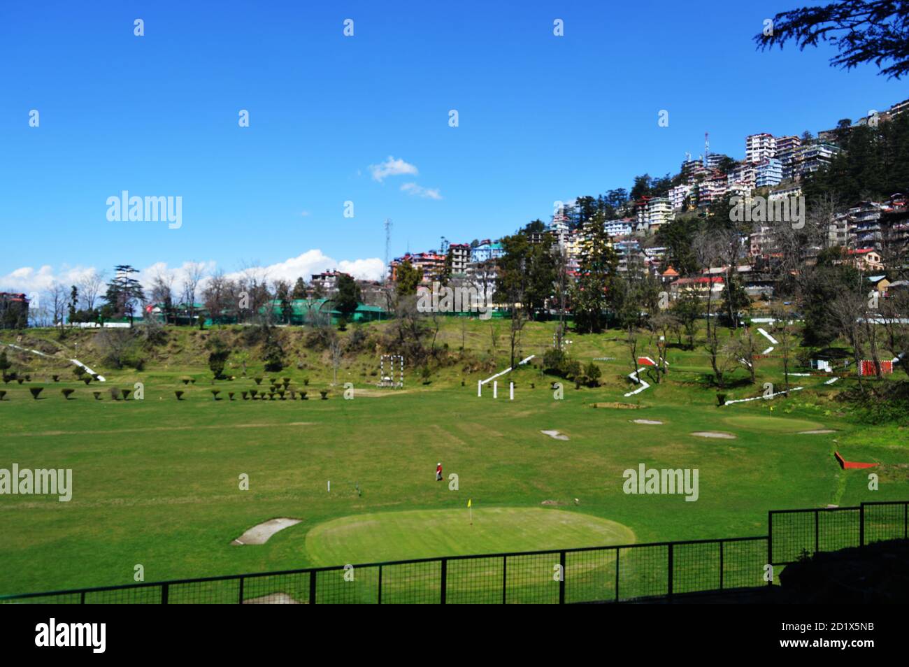 Le terrain de golf vert de Shimla, Himachal Pradesh avec des montagnes, des arbres et des bâtiments en arrière-plan, concentration sélective Banque D'Images