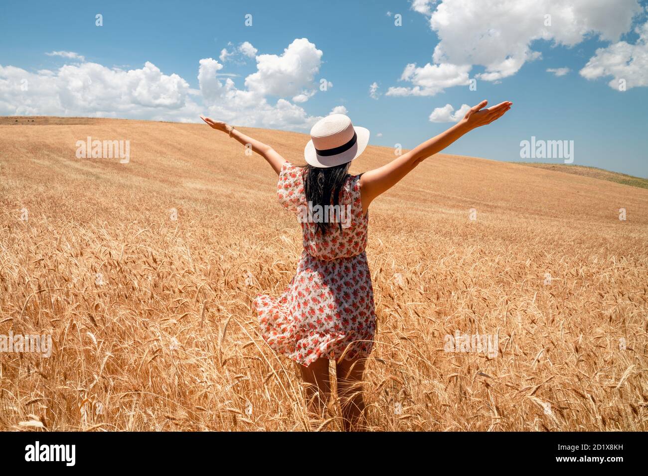 Belle femme est à la recherche du champ de la lande avec ciel bleu et fond de nuages. Agriculture et concept rural. Photo de haute qualité Banque D'Images