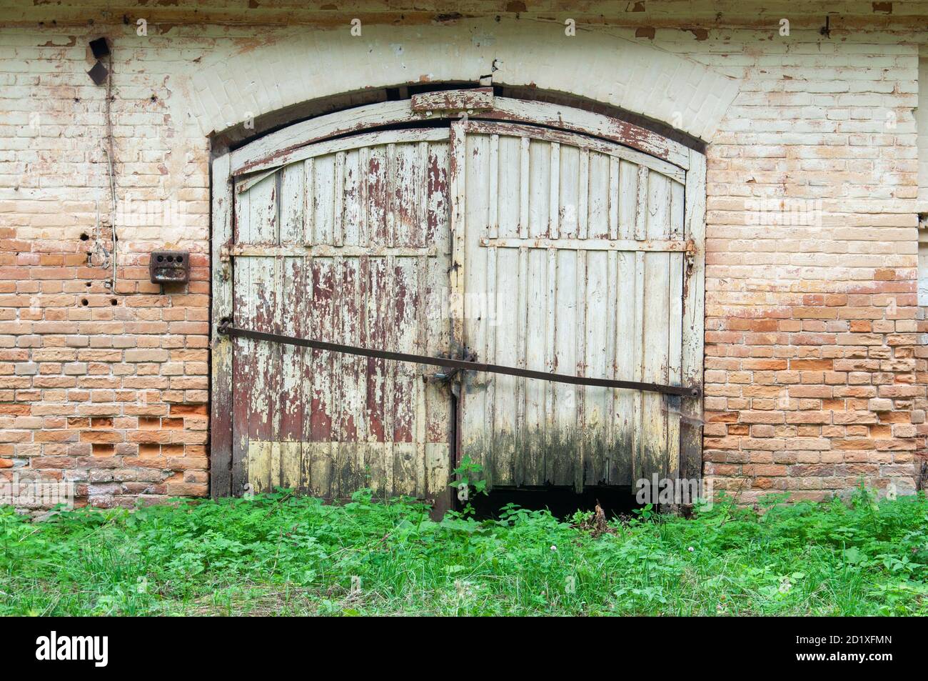 Vieux mur de briques vintage avec doubles portes rouillées Banque D'Images