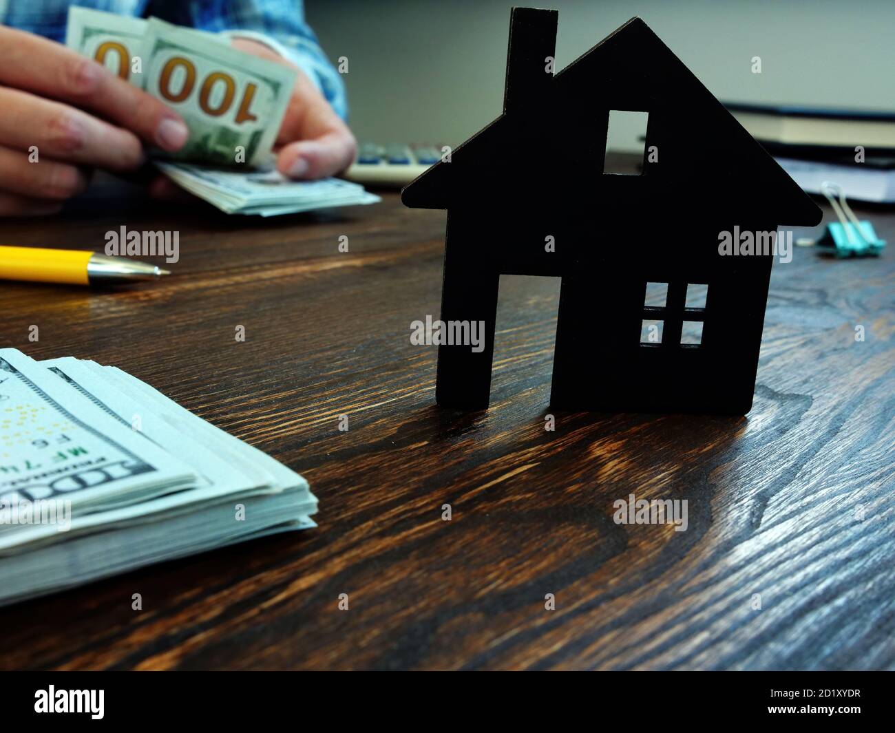 L'homme compte de l'argent pour acheter une maison, une hypothèque ou un loyer. Banque D'Images