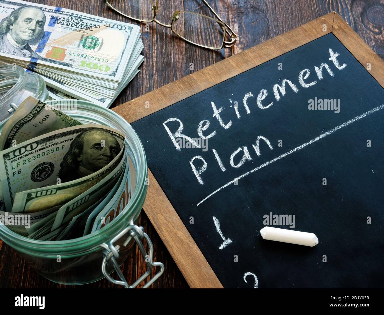 L'argent et le plan de retraite sont écrits à la main sur un tableau noir. Banque D'Images