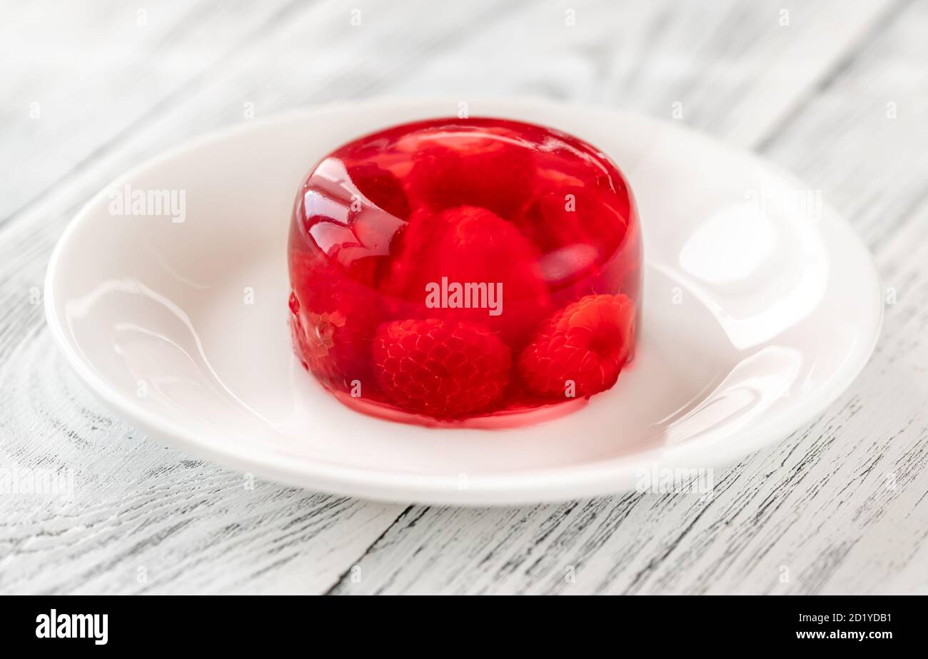 Portion de dessert en gélatine de framboise sur une assiette blanche Banque D'Images Portion de dessert en gélatine de framboise sur une assiette blanche Banque D'Images