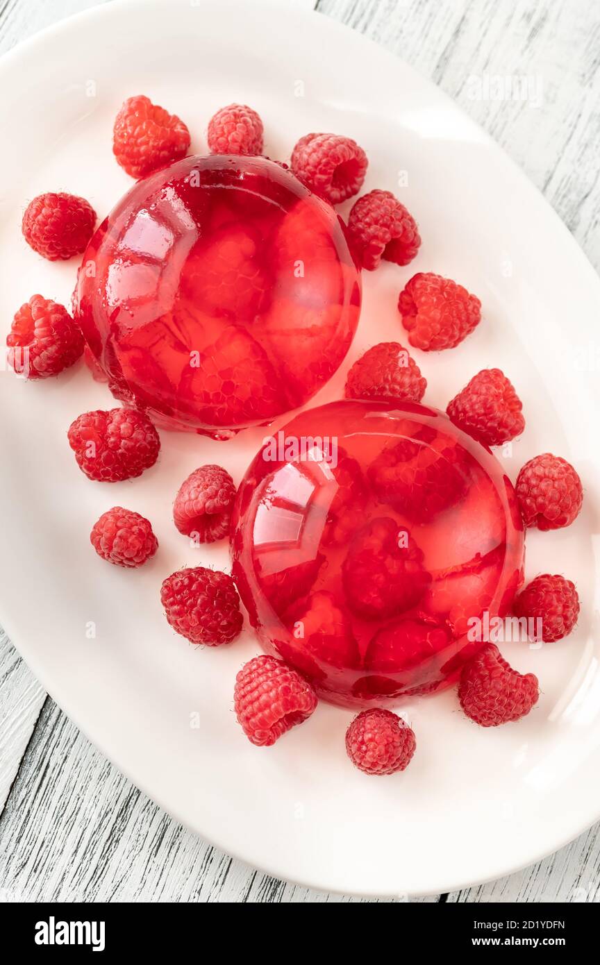 Portion de dessert en gélatine de framboise sur une assiette blanche Banque D'Images Portion de dessert en gélatine de framboise sur une assiette blanche Banque D'Images