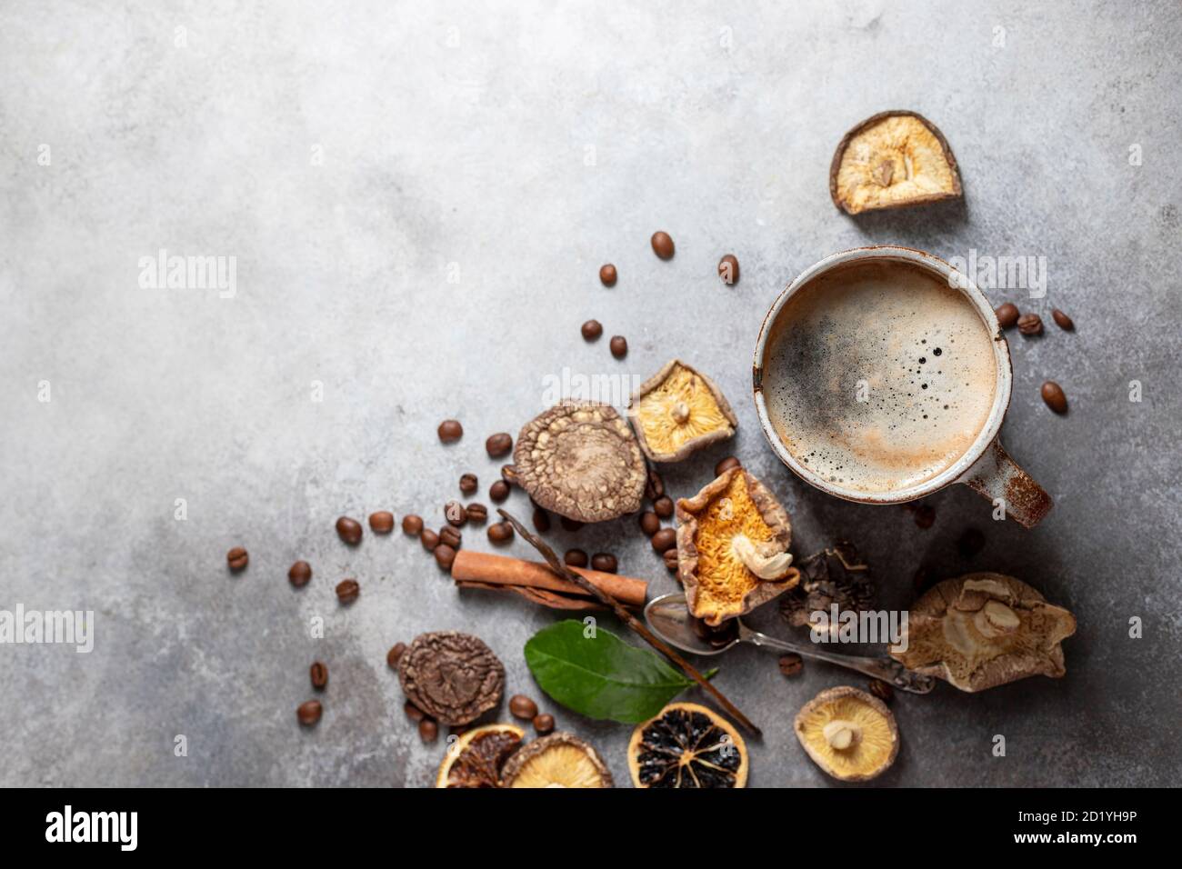Café aux champignons, tasse en céramique, champignons et grains de café sur fond de béton de pierre. Nouvelle tendance des aliments super-alimentaires. Banque D'Images