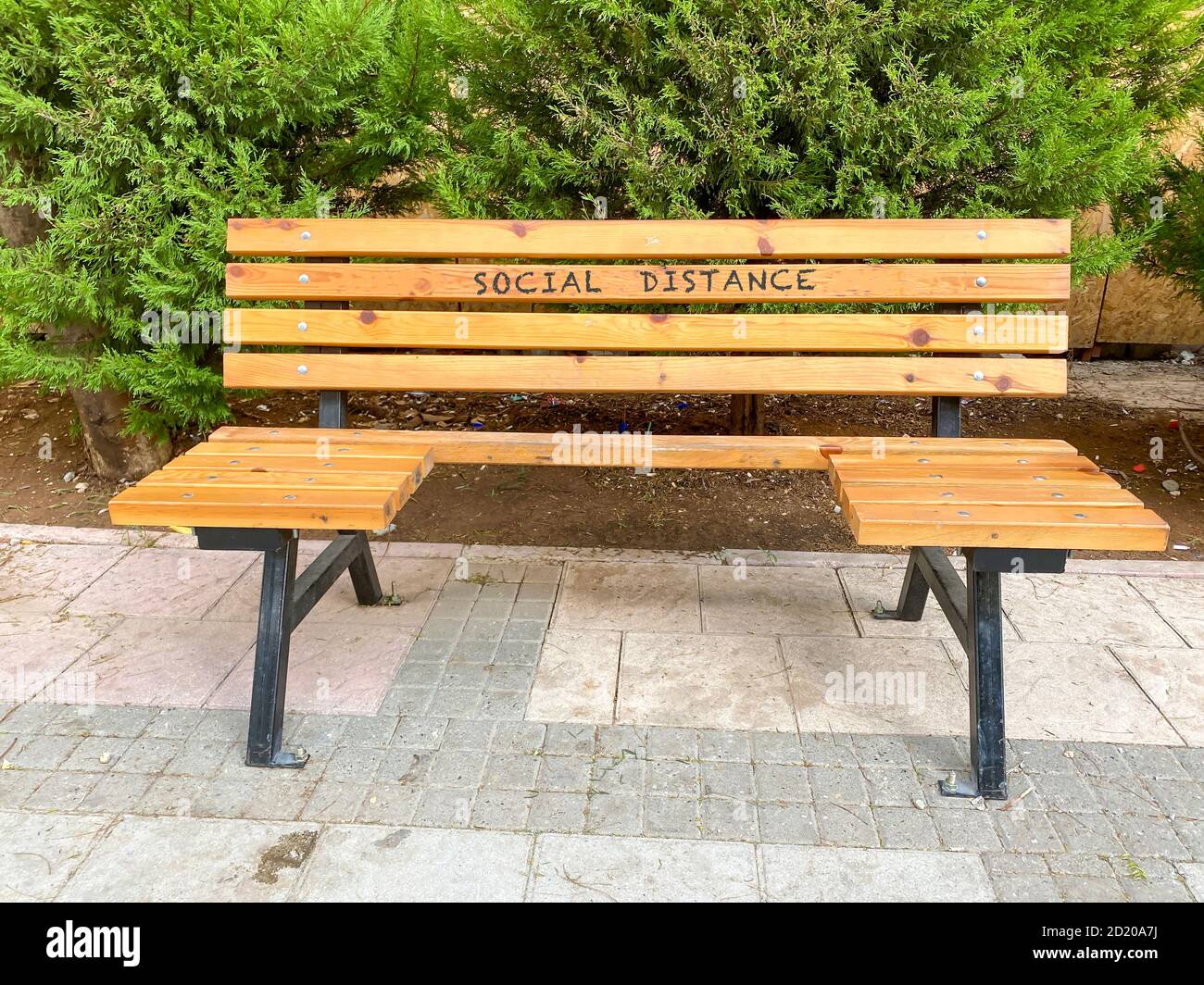 Banc en bois construit pour garder la distance sociale due à l'épidémie de virus corona. Banc en bois dans le parc de la ville Banque D'Images