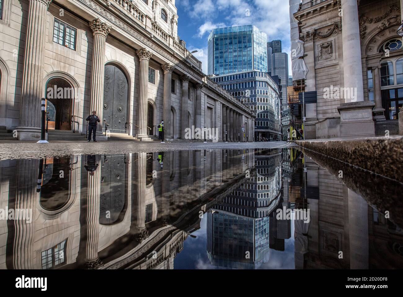 La Bank of England et la Royal Exchange se sont reflétées dans une flaque de pluie après de fortes tempêtes dans la City de Londres, Threadneedle Street, Angleterre, Royaume-Uni Banque D'Images