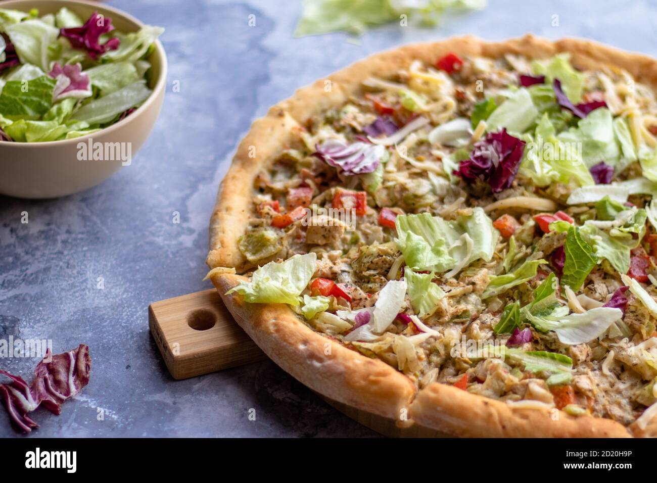 Pizza avec poitrine de poulet barbecue tomates et herbes sur un tableau en bois sur une table en marbre Banque D'Images