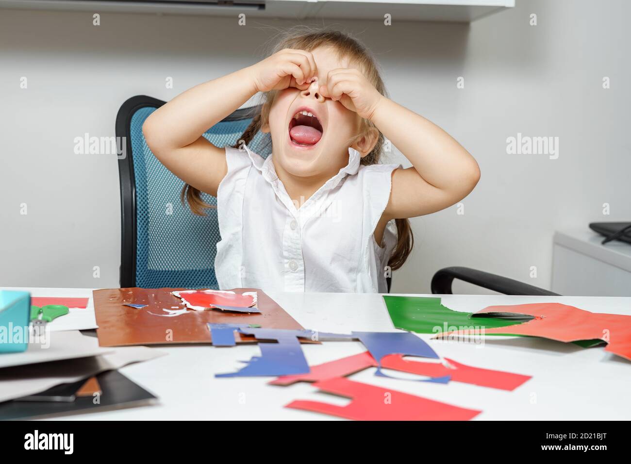 une petite fille pleure parce que l'artisanat en papier ne fonctionne pas. échecs d'enfance Banque D'Images