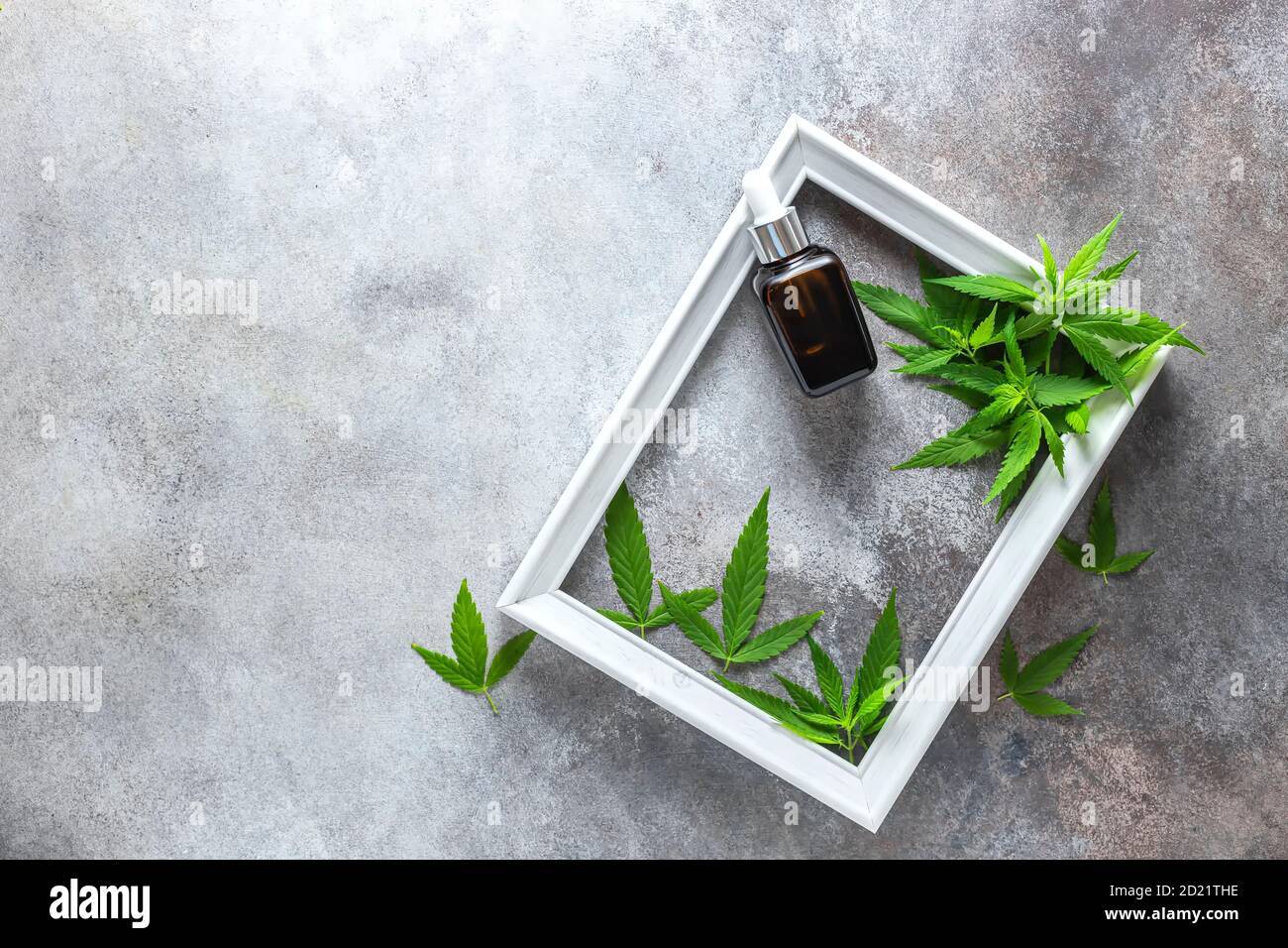 Composition de produits cosmétiques de chanvre dans un pot et feuilles vertes de plantes sur fond blanc de table en bois. Cosmétiques naturels. Huile CBD pour cosmétiques. Banque D'Images