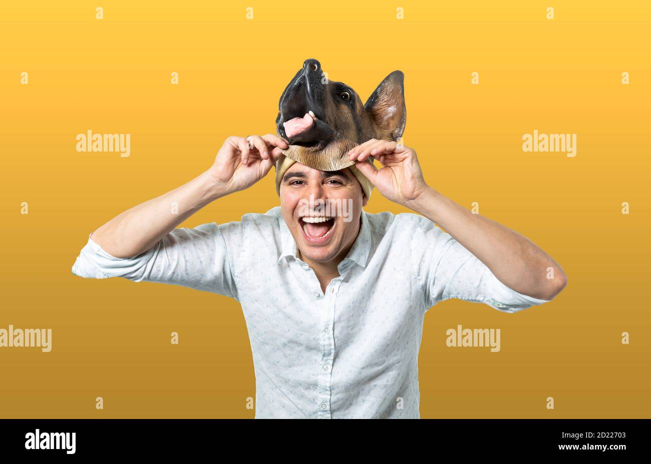Homme prenant le masque de chien et rire. Arrière-plan jaune isolé. Prise de vue moyenne. Banque D'Images