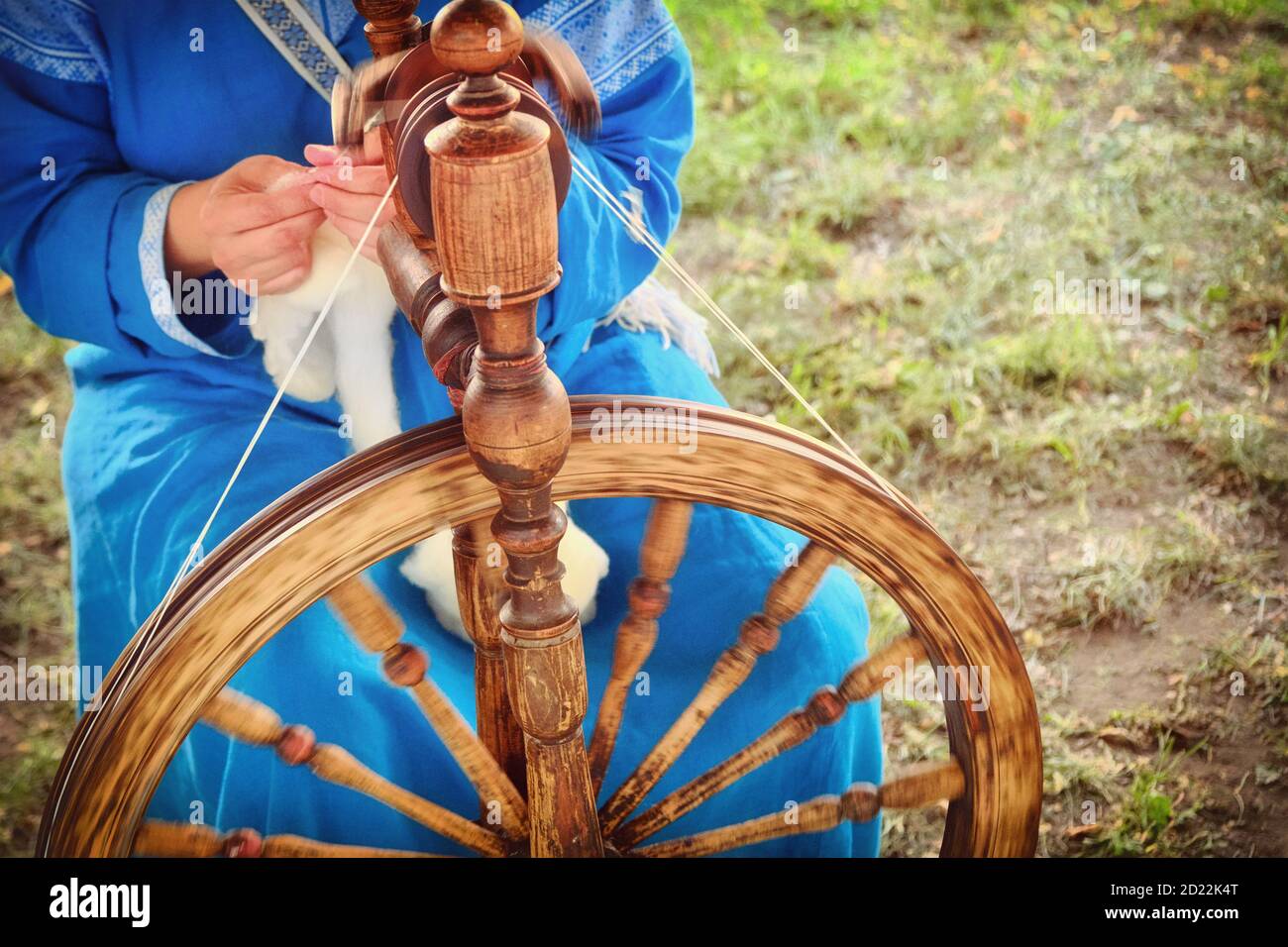 Distaff crée un filetage à partir d'une broche. Roue qui tourne à la main dans la nature, gros plan. Banque D'Images