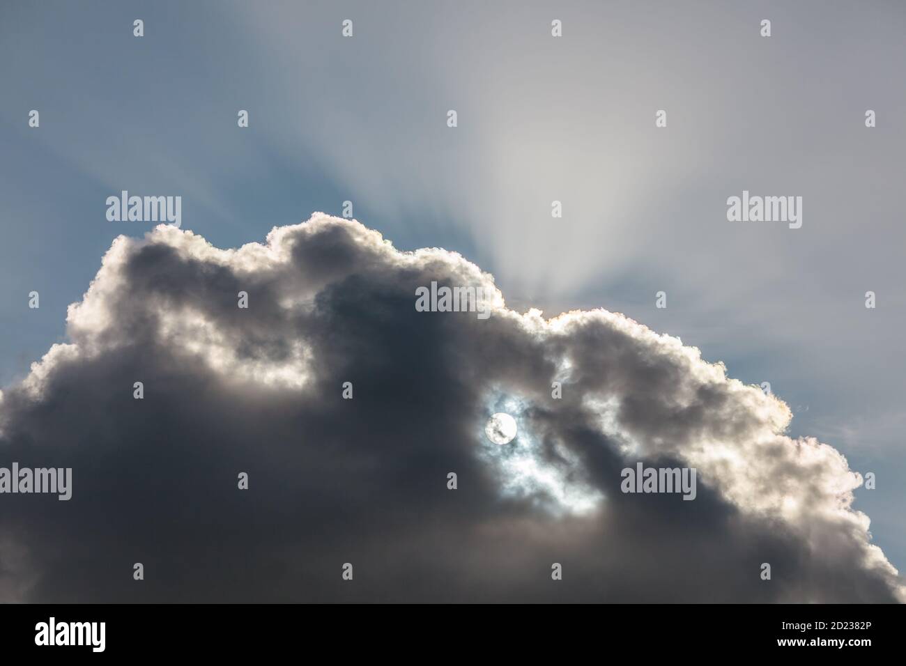 Paysage de nuages gris avec le soleil et les rayons du soleil en arrière-plan Banque D'Images