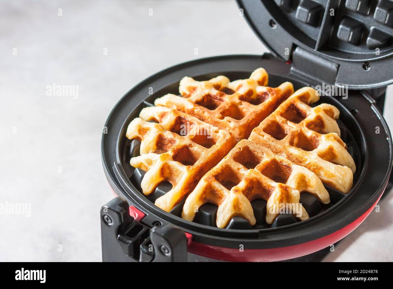 Le processus de fabrication de gaufres faites maison. Gaufres fraîches dans un fer à gaufre. Banque D'Images