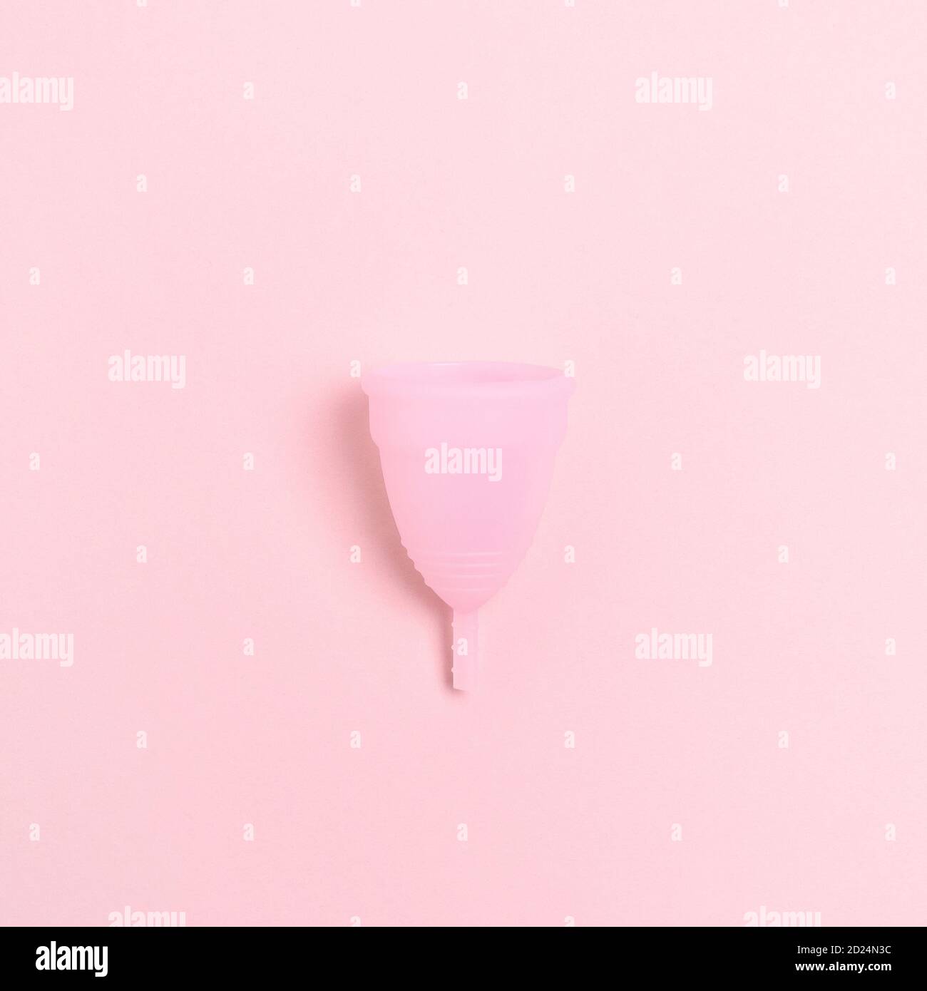 Coupe menstruelle sur fond rose. Composition monochrome Banque D'Images