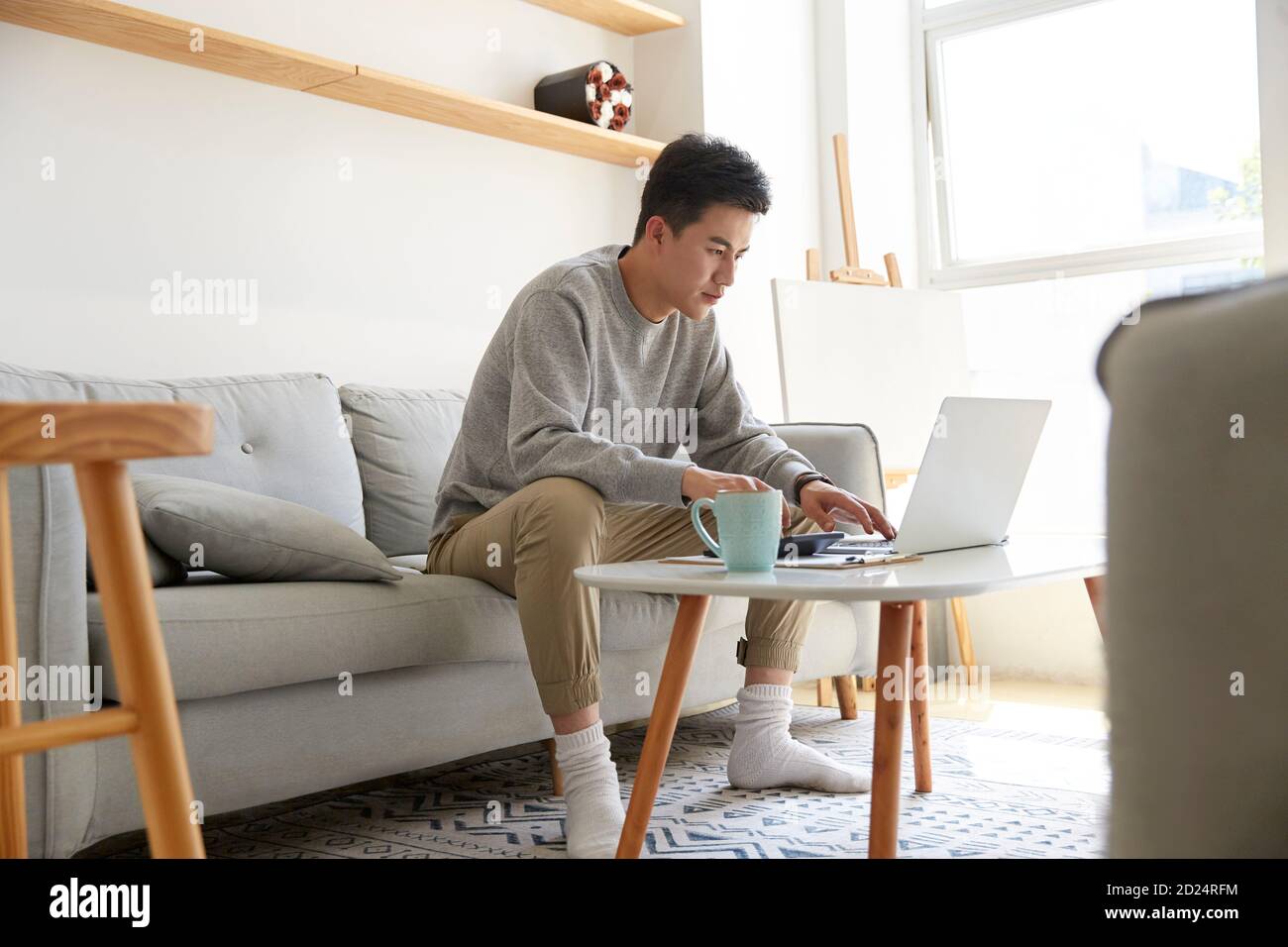 jeune cadre asiatique séjournant à la maison et travaillant avec un ordinateur portable ordinateur Banque D'Images