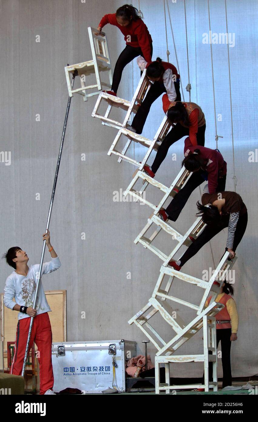 Acrobats train to balance on chairs at an acrobatic troupe in Hefei, east China's Anhui province December 22, 2006. REUTERS/Jianan Yu (CHINA) Banque D'Images