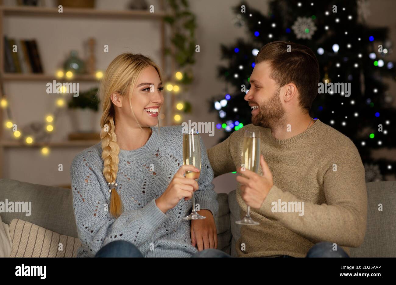 Un homme et une femme heureux qui boit du champagne à la maison Banque D'Images