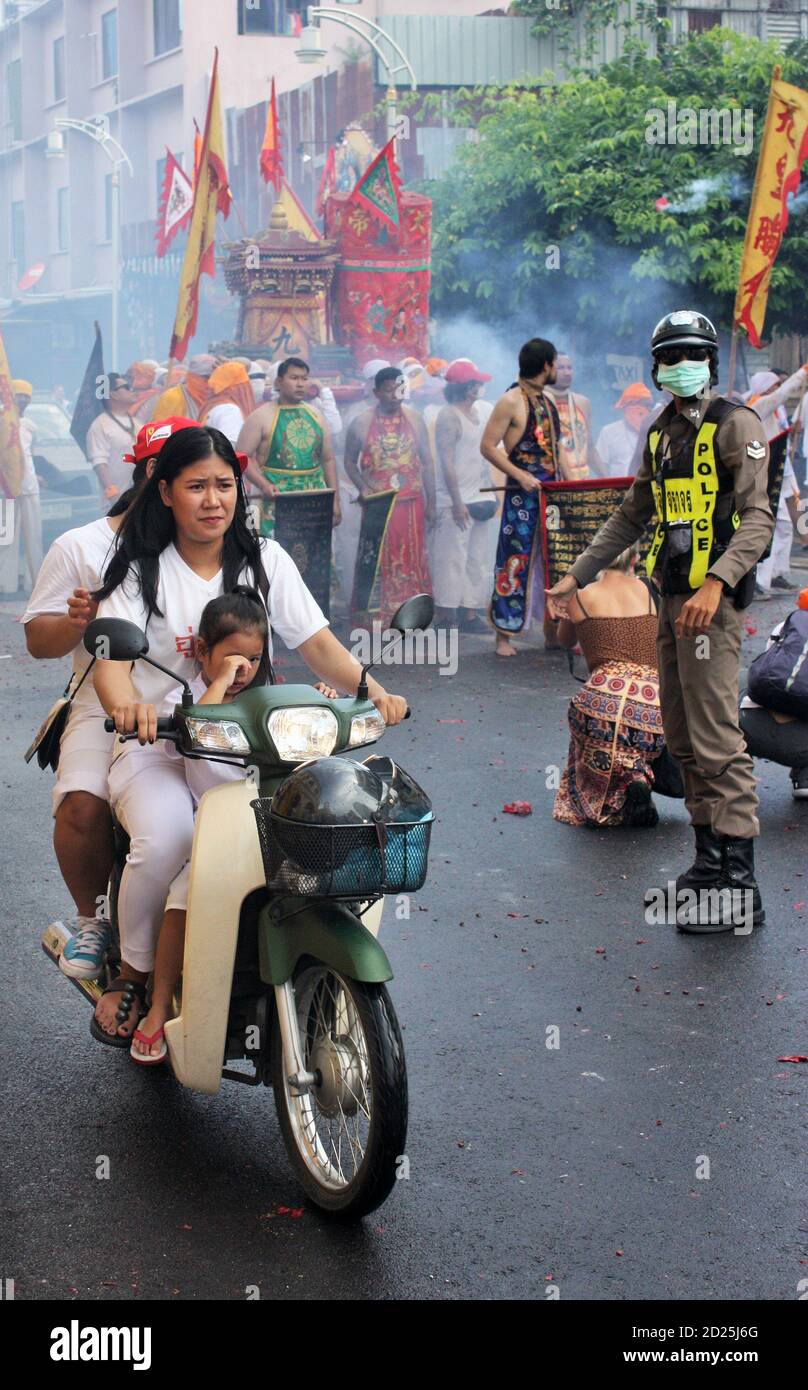 Phuket Town / Thaïlande - 7 octobre 2019 : Festival végétarien de Phuket ou défilé du Festival des neuf dieux de l'empereur avec femme et enfant à moto, policier Banque D'Images