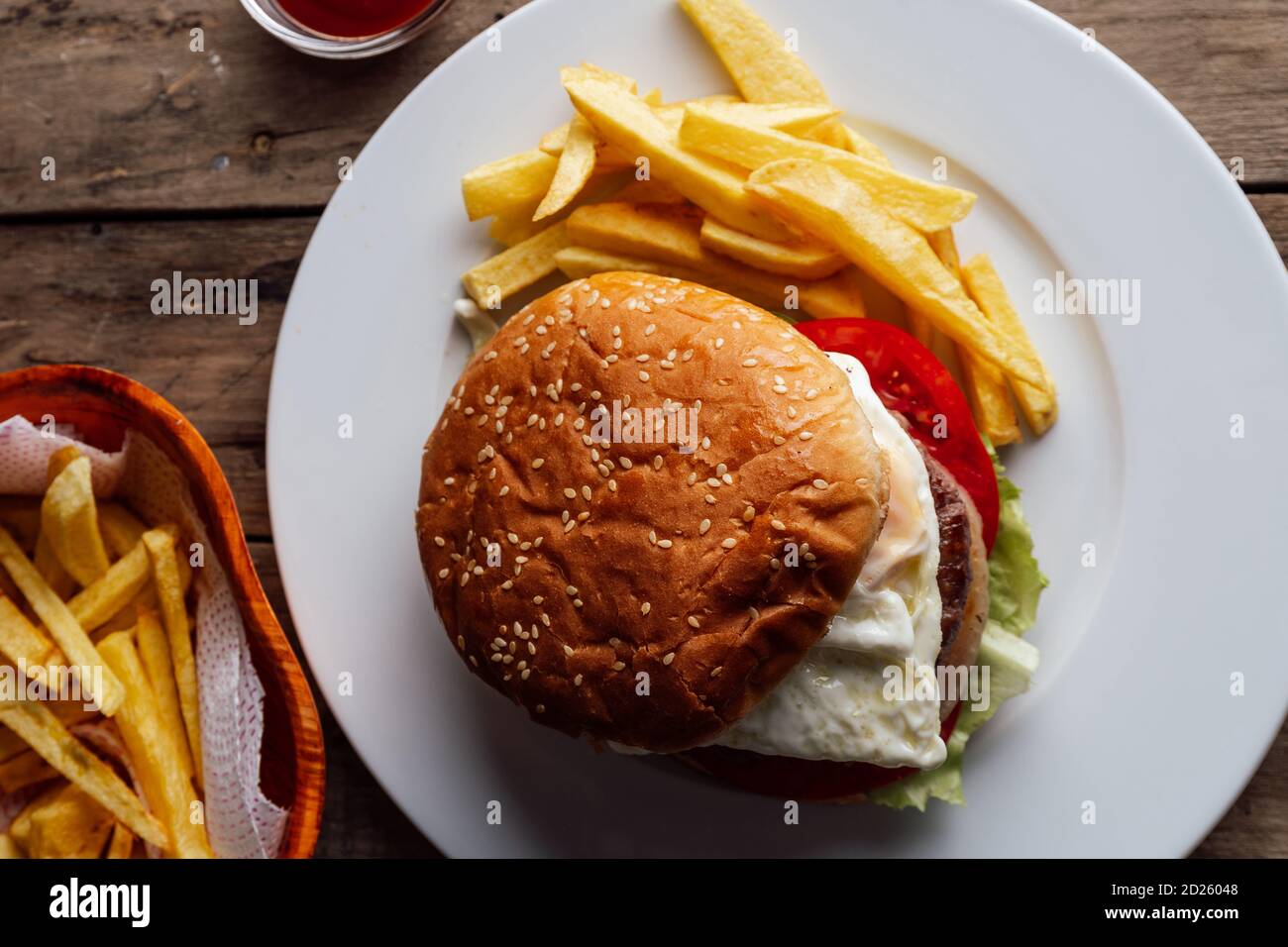 Hamburgers avec œufs et pommes de terre sur une table en bois rustique Banque D'Images