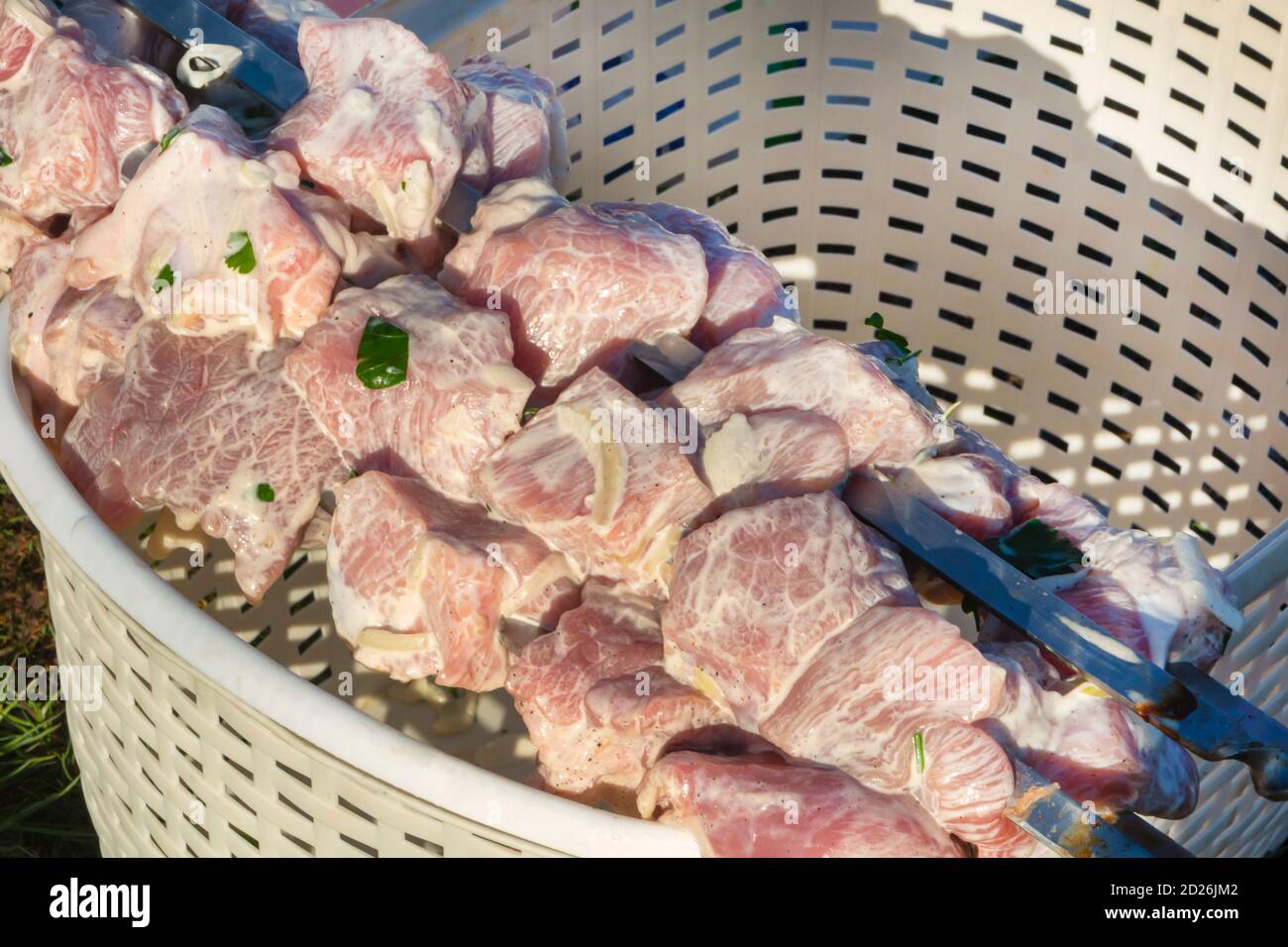 Viande crue dans une sauce crémeuse. Faire griller sur des brochettes pour griller avec des oignons, des herbes et des épices. Viande de porc crue, gros plan, texture de la viande. Banque D'Images