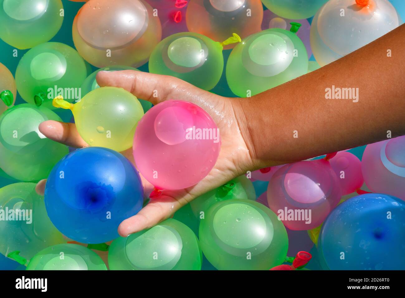 Personne tenant une poignée de bombes à eau colorées en latex ou des ballons de fête en caoutchouc dans un gros plan plein cadre vue Banque D'Images
