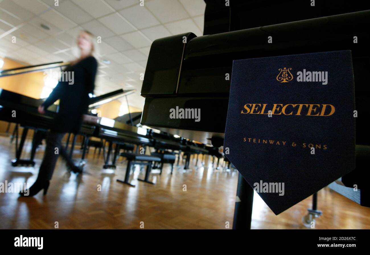 A woman walks past a selected Concert Grand piano in the selection room at  the Steinway & Sons factory in Hamburg February 24, 2009. Steinway & Sons,  a German-based subsidiary of Steinway