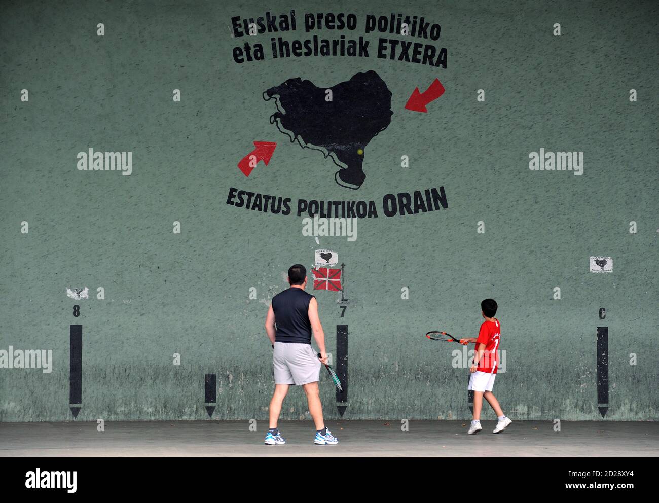 People practise Pelota Vasca (Basque ball) at a court that reads "Basque political prisoners and exiles Home, Political status Now" in Manaria June 14, 2009. REUTERS/Vincent West (SPAIN POLITICS) Banque D'Images