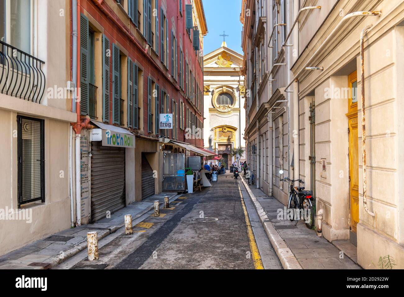 Une ruelle étroite avec café avec vue sur l'église baroque de Saint François de Paule dans le quartier cours Saleya de la vieille ville de Nice France. Banque D'Images Une ruelle étroite avec café avec vue sur l'église baroque de Saint François de Paule dans le quartier cours Saleya de la vieille ville de Nice France. Banque D'Images