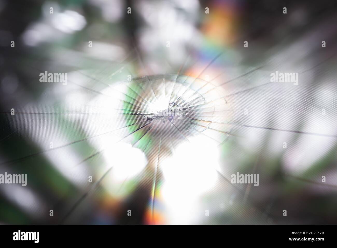 arrière-plan abstrait de l'écran lcd tft cassé avec fissures radiales localisées d'un seul coup : gros plan avec mise au point sélective et flou Banque D'Images