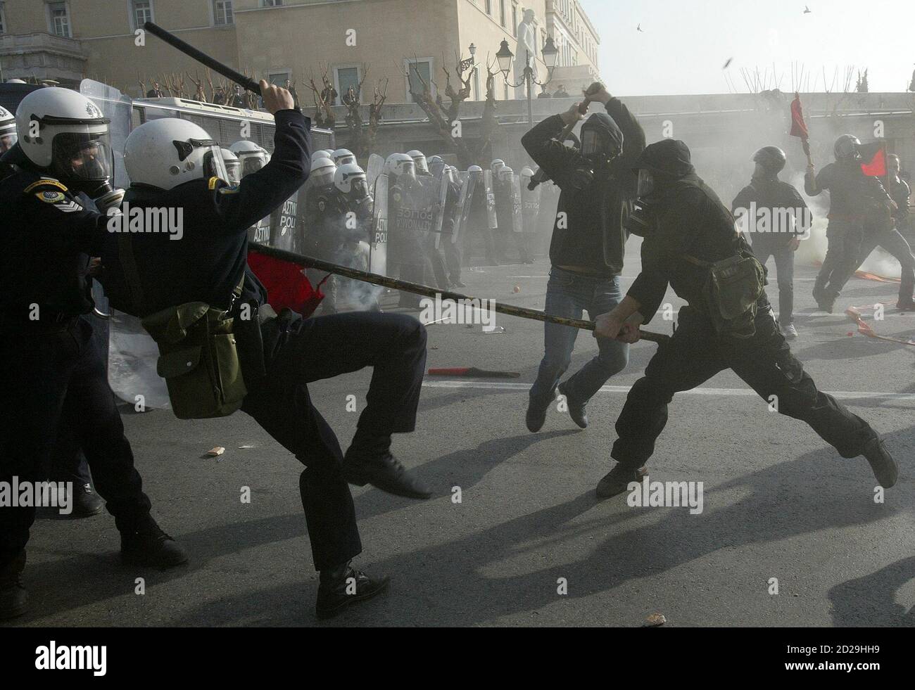 Des anarchistes autostylisés armés de bâtons de bois attaquent la police devant le Parlement grec à Athènes le 22 février 2007. Des affrontements ont éclaté après que les manifestants aient tenté de briser un cordon de police alors que des milliers d'étudiants ont défilé à Athènes pour protester contre les projets du gouvernement visant à réformer l'enseignement supérieur et à introduire des universités privées. REUTERS/John Kolesidis (GRÈCE) Banque D'Images