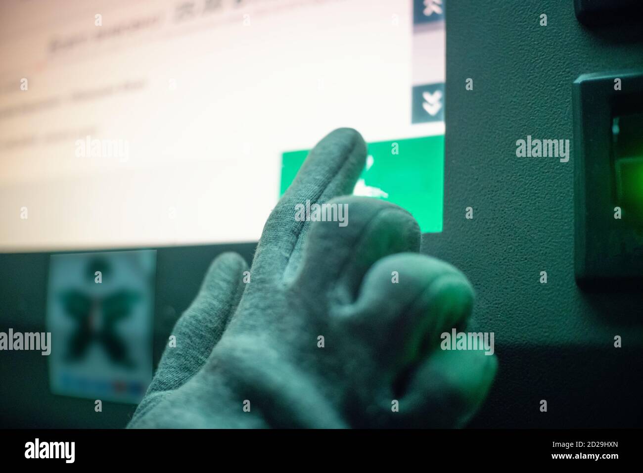 Les femmes gantées de la main appuie sur l'écran tactile Infokiosk nuit Banque D'Images
