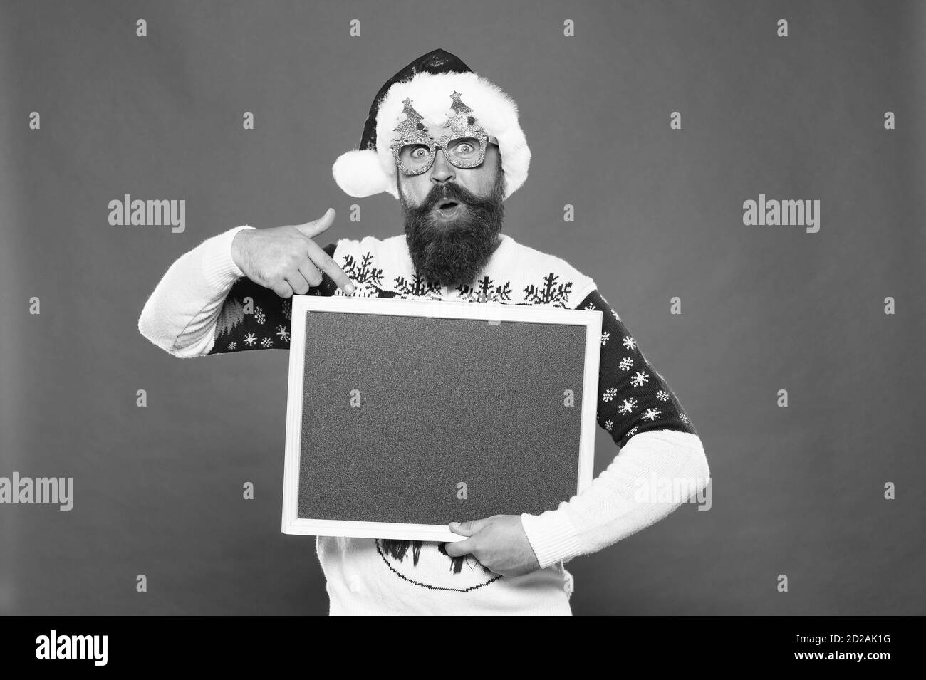 Invitation à une fête. Le Père Noël. Homme barbu blank blackboard copier l'espace. Guy santa fond rouge. Tableau d'information. Présentation concept. Annonce l'hiver. L'événement d'hiver. Maison de vacances d'hiver. Banque D'Images