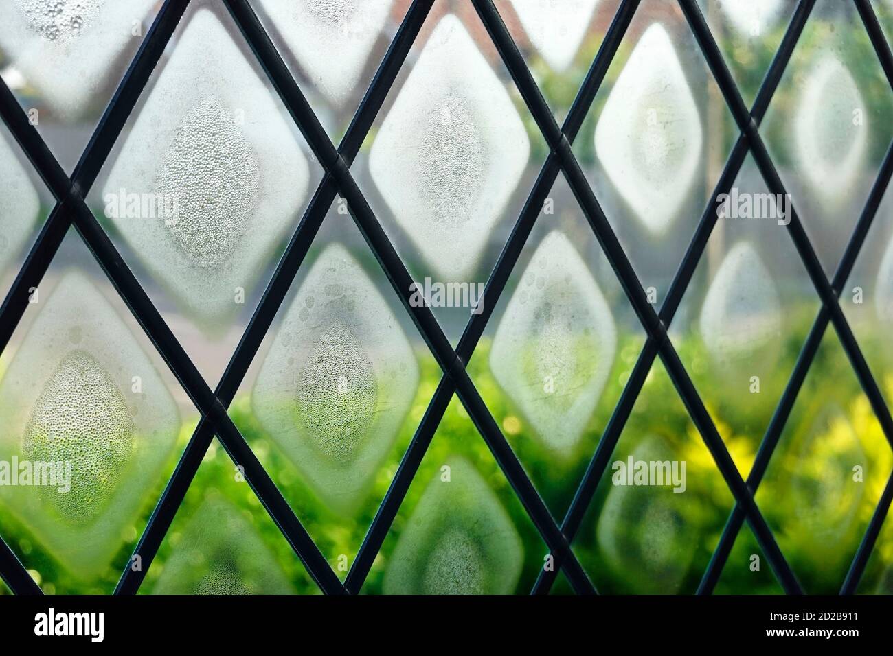 Le joint de la fenêtre à double vitrage et est défectueux et grillé le brouillard de condensation entre le verre imite la forme des lumières au plomb diamant Formes Angleterre Royaume-Uni Banque D'Images