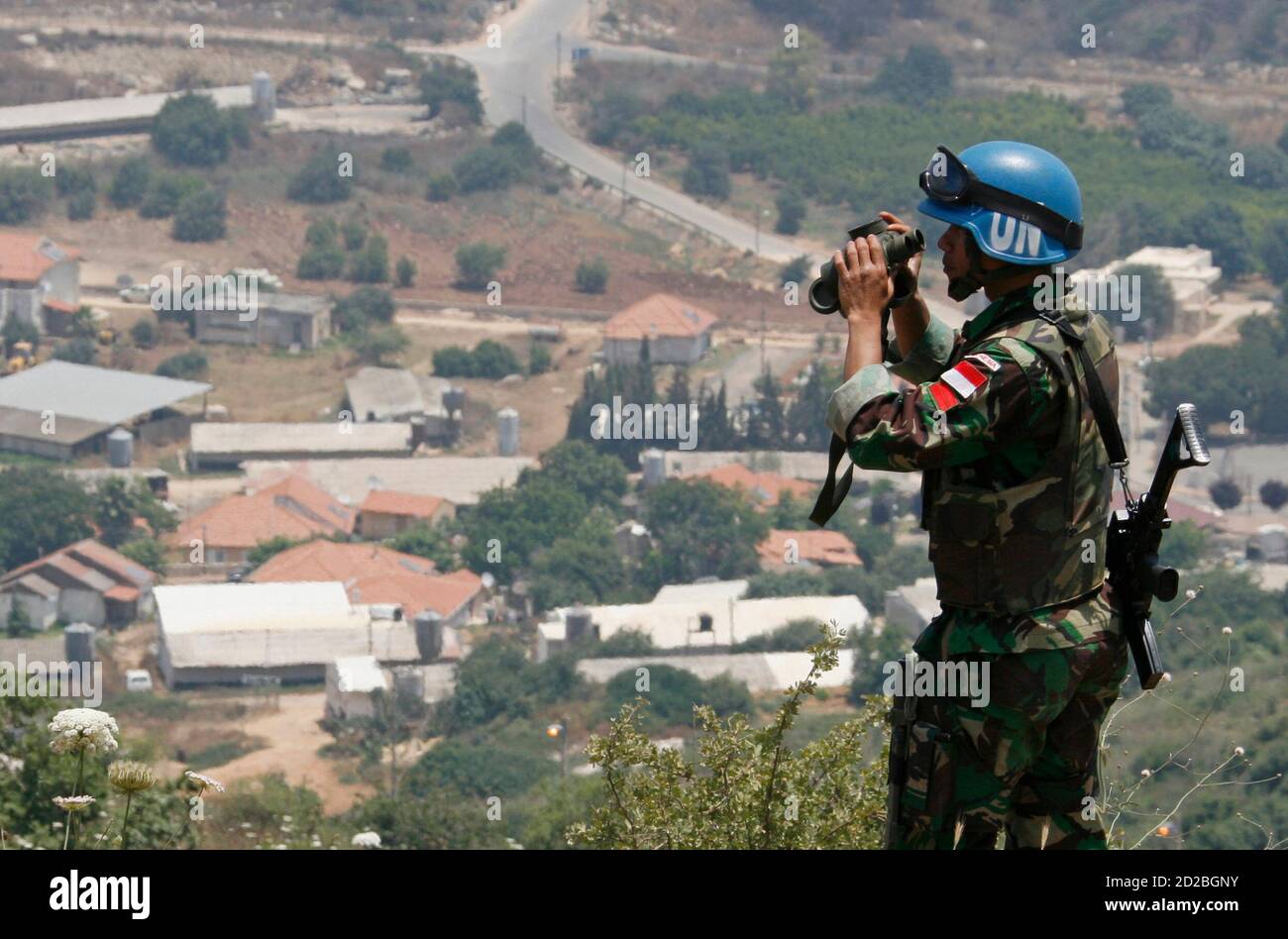 A . peacekeeper from Indonesia uses a pair of binoculars to monitor the  border with Israel in Houla village, southern Lebanon June 18, 2007. Two  Katyusha rockets hit the northern Israeli town