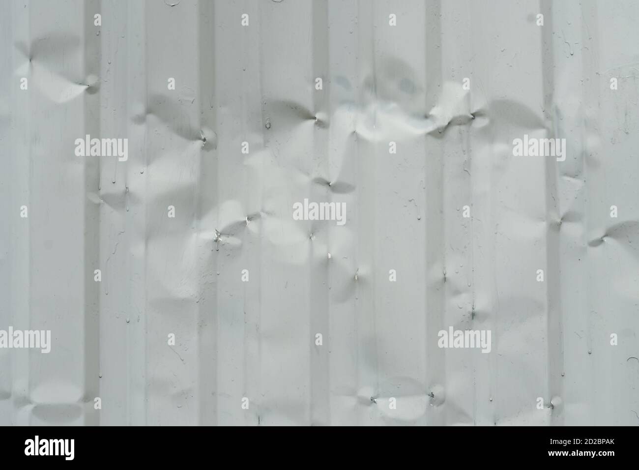 Texture, arrière-plan d'une ancienne clôture en métal ondulé gris Banque D'Images