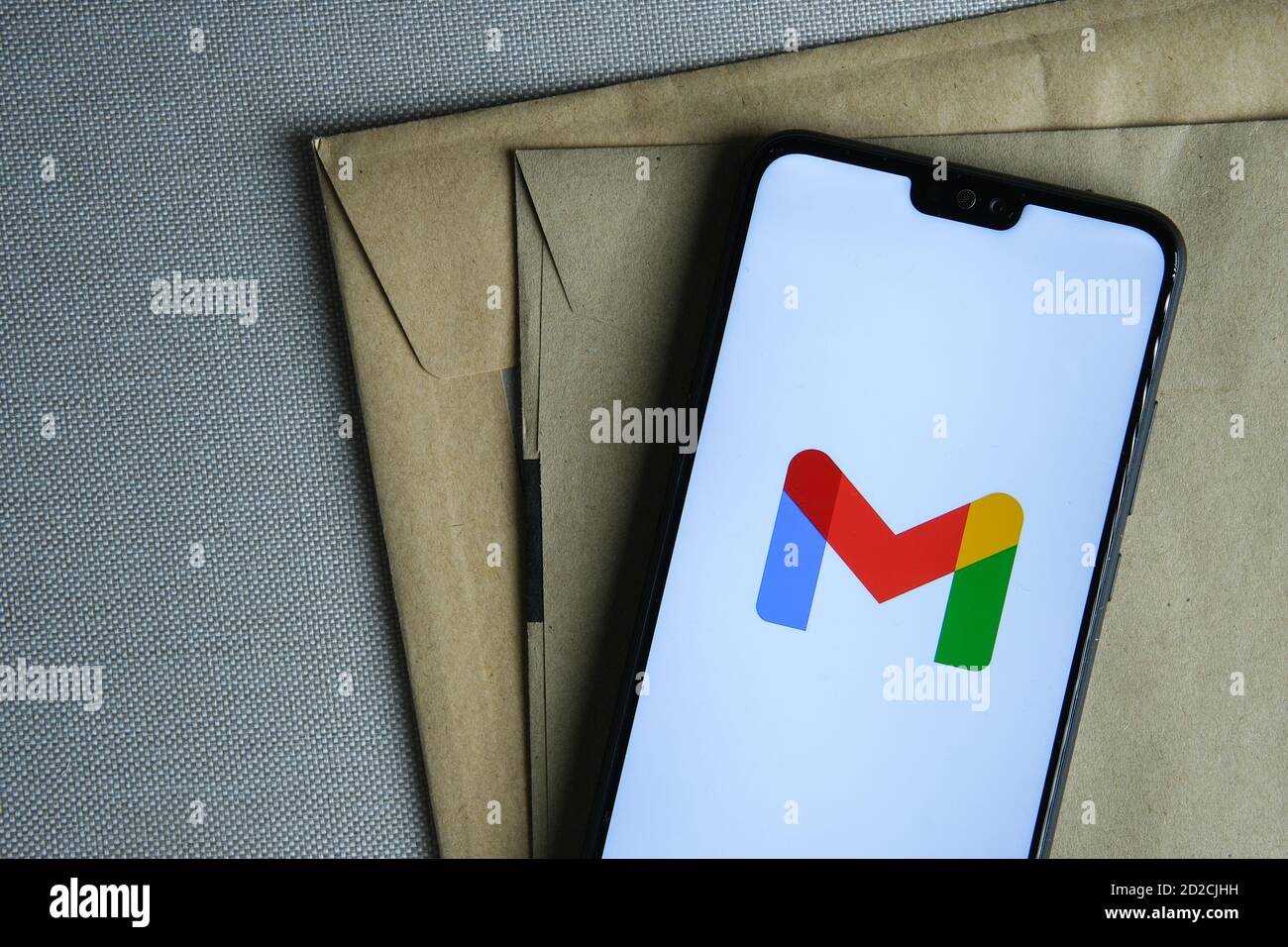 Stafford / Royaume-Uni - octobre 6 2020: Nouveau logo Google Gmail rebaptisé vu sur l'écran du smartphone placé sur des enveloppes brunes. Concept. Banque D'Images
