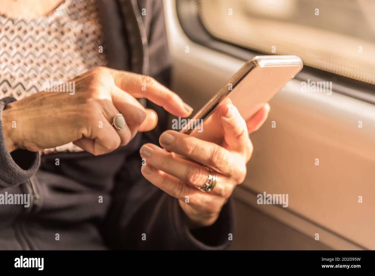 Les mains d'une femme adulte s'approchent d'écrire un texte sur le mobile dans le train Banque D'Images