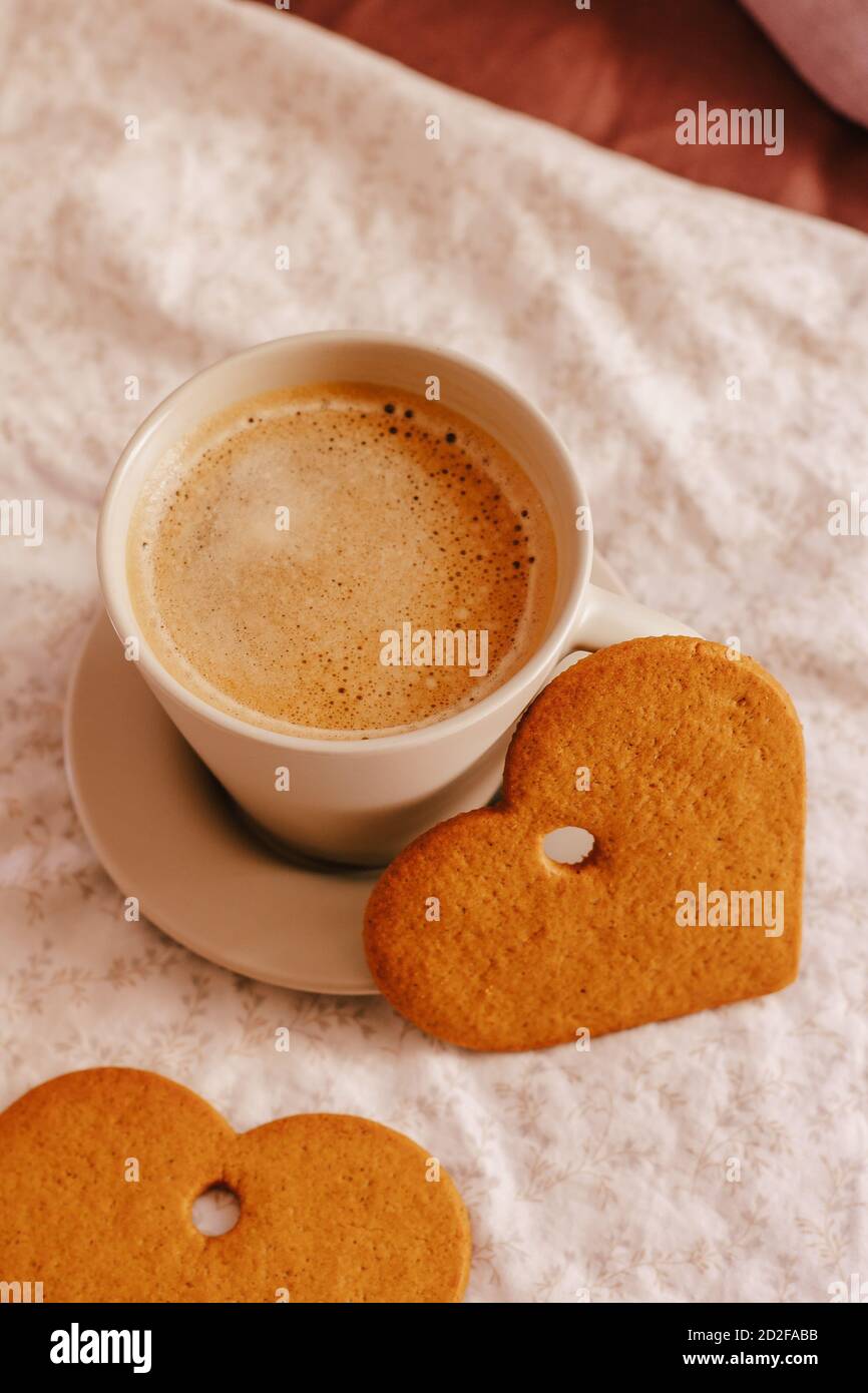 Photo verticale d'une tasse de café et de biscuits en forme de cœur Banque D'Images