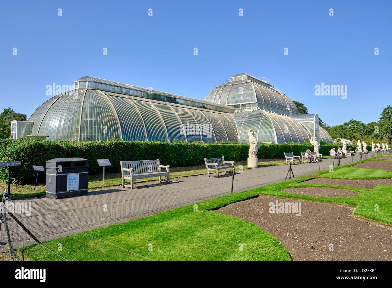 Vue en perspective de la Palm House dans les jardins botaniques royaux, Kew à Richmond sur la Tamise, dans un ciel bleu clair. Banque D'Images