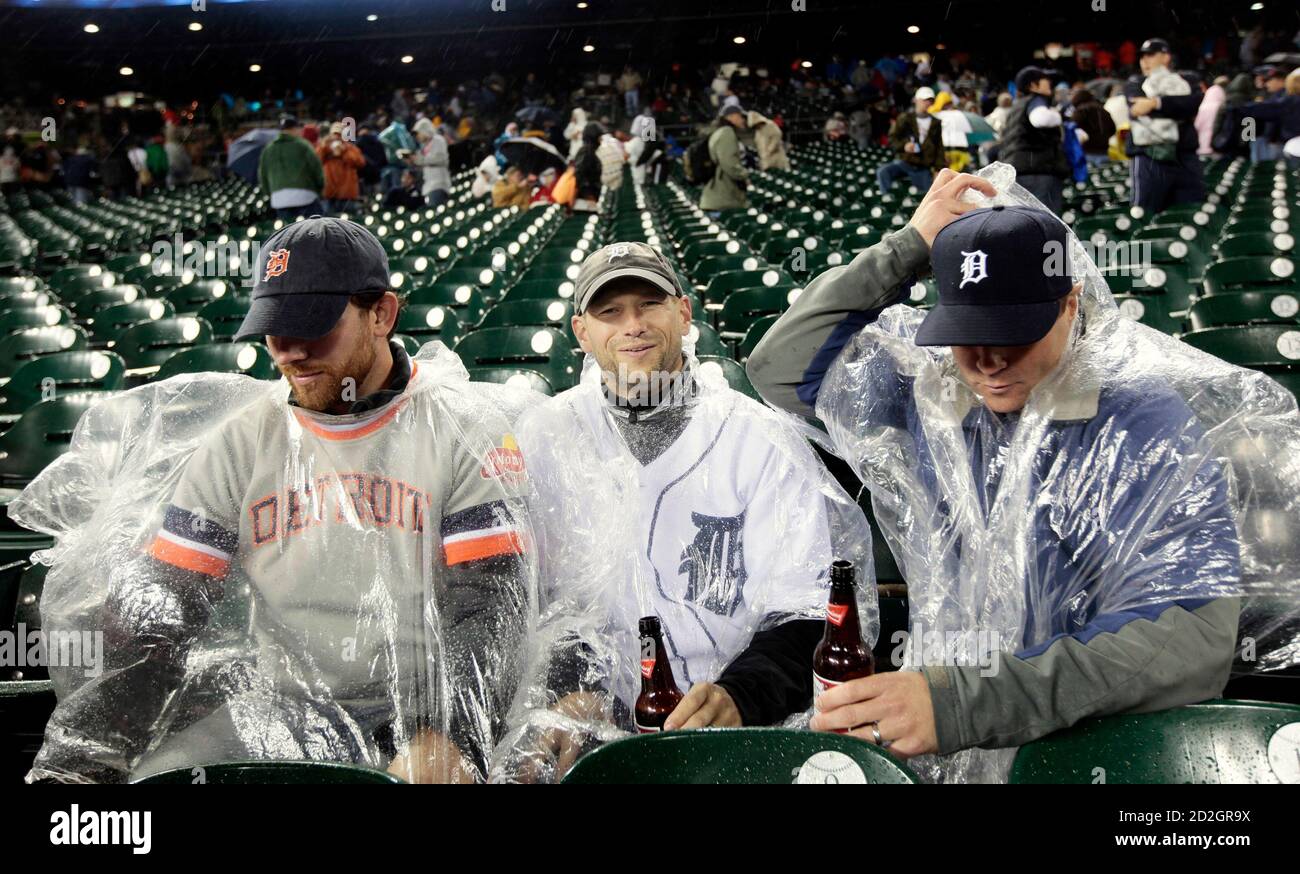 Baseball fans Rob Henkelman (L), Brad Ashcroft (C) and Curtis Madley from  Alberta, Canada adjust their rain ponchos while other fans leave Comerica  Park after the MLB American League baseball game between